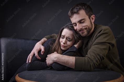 Young Man Comforting His Girlfriend Hugging Her And Keeping Her From