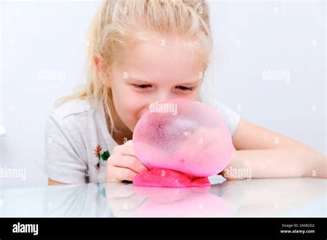 Blonde Girl Inflating Bubble From Pink Glitter Slime Playing Slime Toy Making Slime At Home