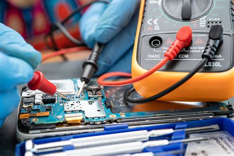 Technician Repairing Inside Of Mobile Phone By Soldering Iron