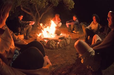People Sitting Around Campfire In Dark Night Wallpaper Photos