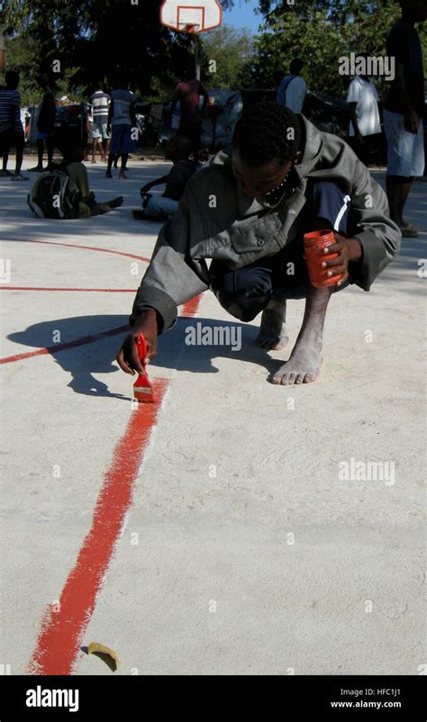 A Haitian Boy Paints Foul Lines On The Basketball Court At The Lifeline