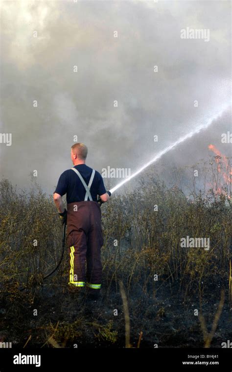 Firefighter Tackling A Grass Fire Stock Photo Alamy