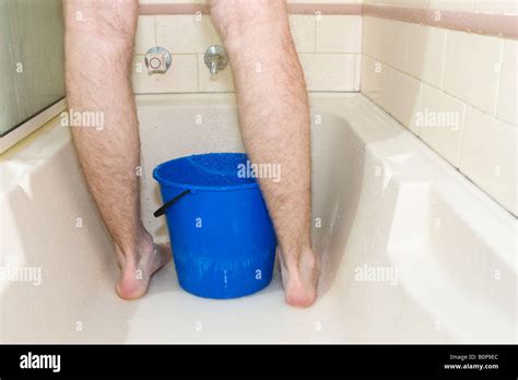 A Bucket Placed Beneath A Shower To Collect Water For Reuse Stock Photo
