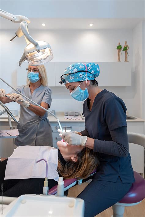 Professional Dentists Treating Teeth Of Female Patient Stock Image