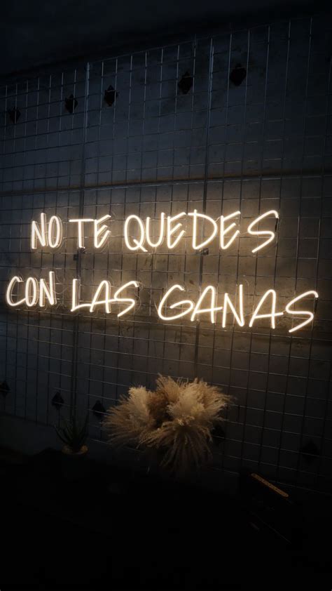 a neon sign that says no te quedes con las ganas on the wall