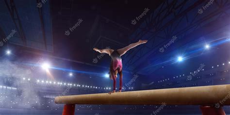 Free Photo Female Gymnast Doing A Complicated Trick On Gymnastics Balance Beam In A