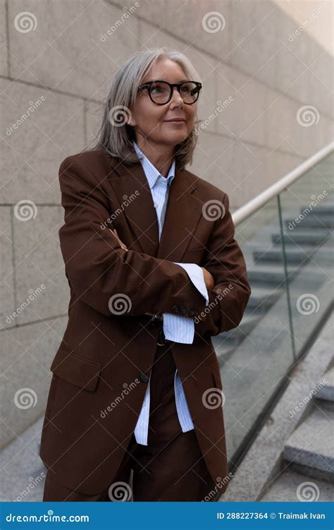 close up of a slender well groomed pretty gray haired business woman pensioner standing on the