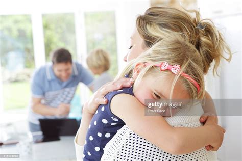 Daughter Cuddling Mother Photo Getty Images