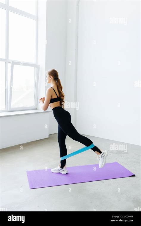 Fitness Woman Doing Exercise For Glutes With Resistance Band On Gray Background Athletic Girl