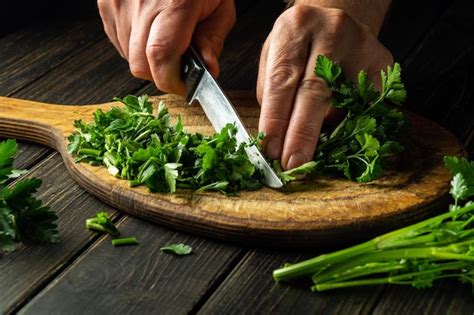 Premium Photo Cook Cutting Green Parsley On A Cutting Board With A Knife