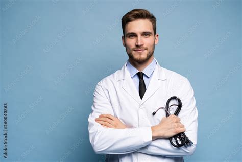 Portrait Of Confident Young Medical Doctor On Blue Background Stock