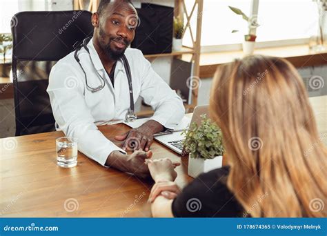African American Doctor Consulting For Patient Working In Cabinet