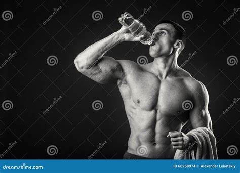 Muscular Man Drinks Water On A Dark Background Stock Photo Image Of