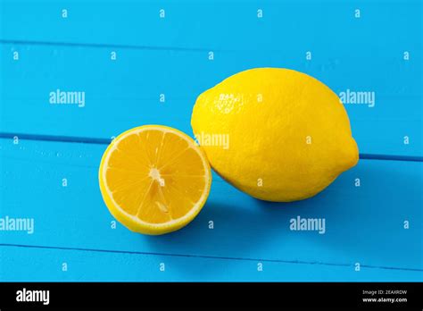 One Whole And One Half Cut Fresh Lemon On Blue Table Background Stock