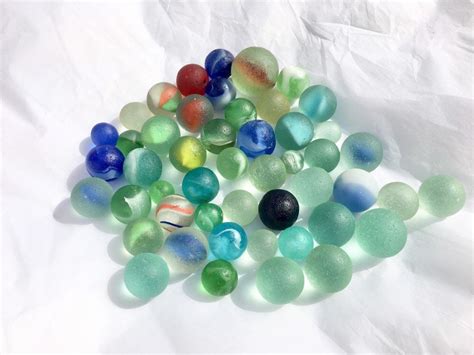 Several Different Colored Marbles On A White Surface
