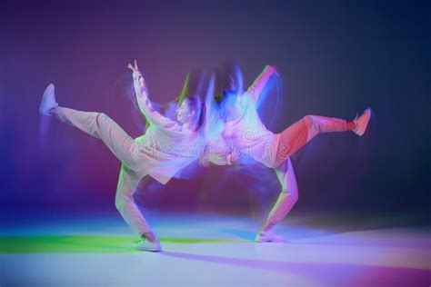 Portrait Of Young Girls Dancing Hip Hop Over Gradient Blue Purple Background In Neon With Mixed