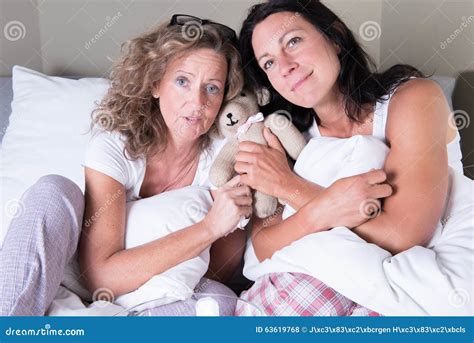 Two Attractive Women Sitting In Bed And Dreaming Stock Photo Image Of