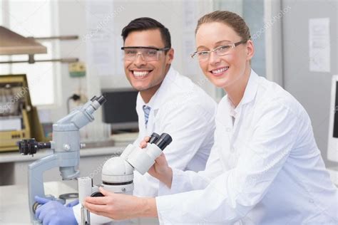 Happy Scientists Using Microscope Royalty Free Stock Photos