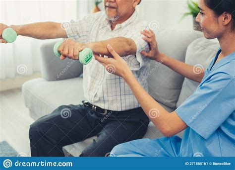 Contented Senior Patient Doing Physical Therapy With The Help Of His