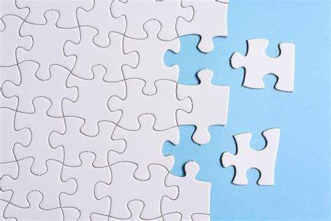 White Jigsaw Puzzle With Some Missing Pieces On Blue Background Copy