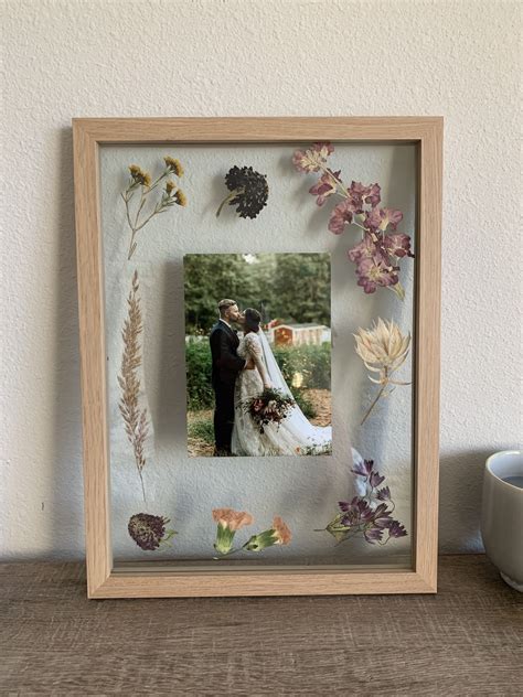 A Wooden Frame With Flowers And Leaves On It Next To A Coffee Cup In