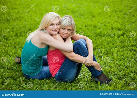 Two Girls Sitting On The Grass Embracing Stock Image Image Of Leisure Beauty 20832309