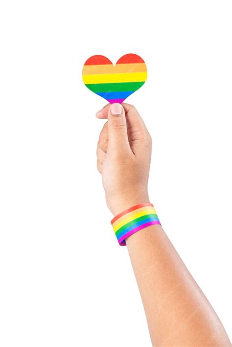 Premium Photo Human Hand With Lgbt Rainbow Flag Wristband Holding Rainbow Heart Isolated Over