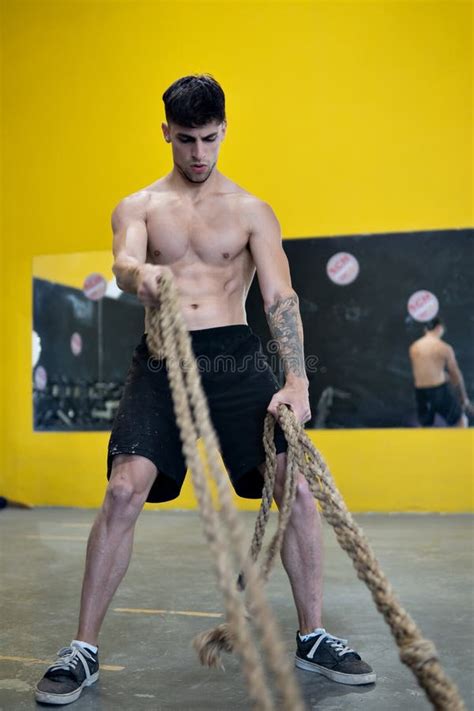 Fit Man Working Out With Battle Ropes At Fitness Gym Stock Photo