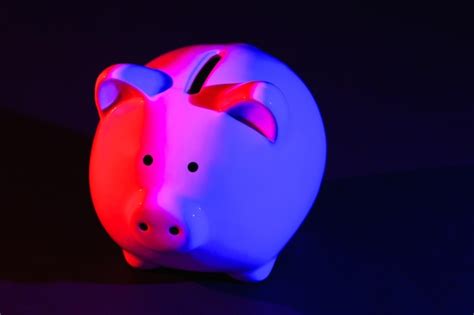 Premium Photo Piggy Bank On A Dark Background With Redblue Backlight