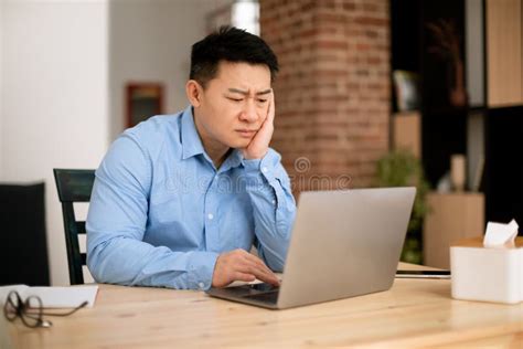 Sad Tired Middle Aged Asian Man Working On Laptop Computer Sitting At