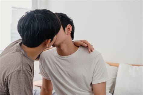 アジアの同性愛者のカップルが自宅のベッドでキスします。若いアジアのlgbtq 男性は幸せな休息を一緒にリラックスして、午前中に自宅の寝室で目覚めた後、ロマンチックな時間を過ごします。 無料の写真