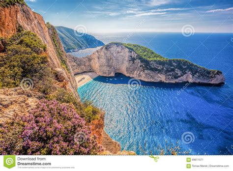 Navagio Beach With Shipwreck And Flowers Against Sunset On
