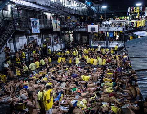 Inmates Sleep On The Ground Of An Open Basketball Court Inside The