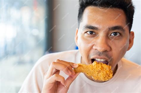 Premium Photo Man Eating Fried Chicken Leg In Brunch Meal At