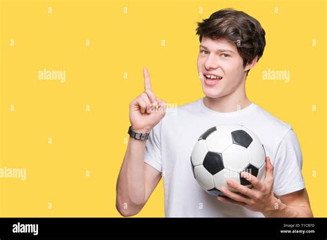 Young Man Holding Soccer Football Ball Over Isolated Background