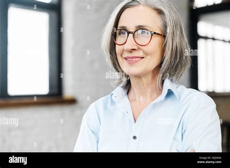 Headshot Portrait Of A Charming Smiling Elegant Senior Woman In Glasses Standing And Looking