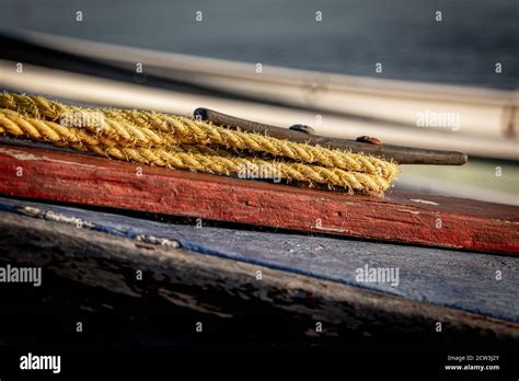 A Close Up Of Boat Ropes Tied Up Around The Cleat Of A Wooden Boat