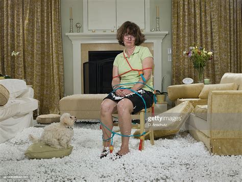 Woman Tied To Chair In Mess Of Packing Peanuts With Dog Watching In