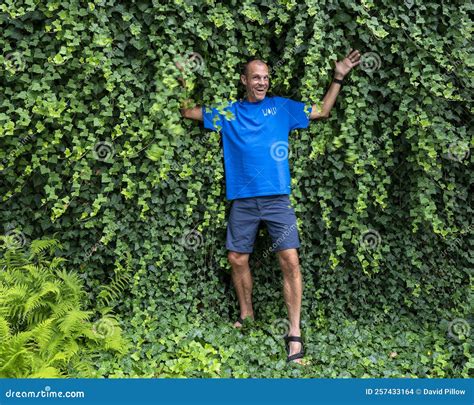 47 Year Old Caucasian Male Posing In Front Of A Dense Wall Of Green Ivy In Bar Harbor Maine