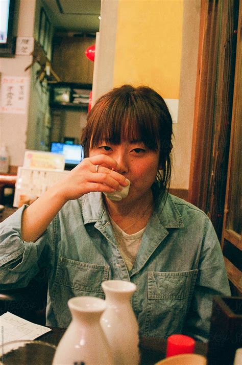 Sultry Japanese Woman Drunkenly Sipping Sake By Kayla Johnson Stocksy