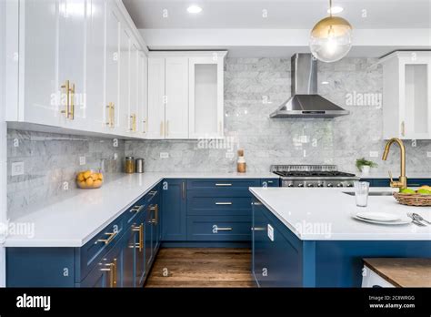 A Luxurious White And Blue Kitchen With Gold Hardware Bosch And