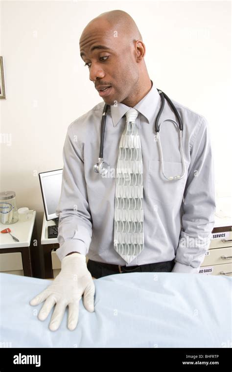 Doctor Conducting Medical Exam On Abdomen In Doctors Office Patient