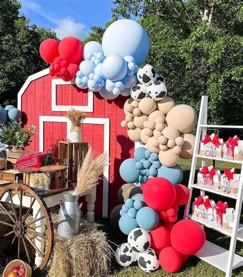 A Red Barn Decorated With Balloons Hay And Farm Animals For An Outdoor