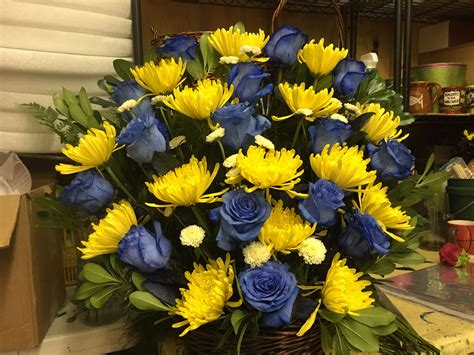A Basket Filled With Blue And Yellow Flowers On Top Of A Counter Next