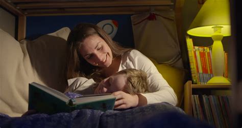 Like many others, the traditional bedtime story was an important part of our childhood. Bedtime Story Reading Mum And 7 Year Old Son Stock Footage ...
