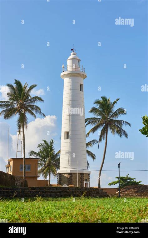 Daytime Shot Of Famous Galle Lighthouse Surrounded By Coconut Trees In