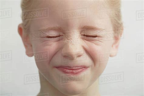 Portrait Of Young Girl Eyes Closed Tightly Close Up Stock Photo
