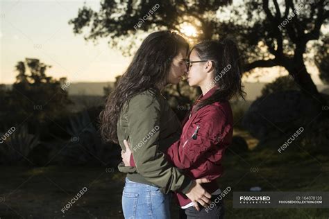 Молодая пара лесбиянок целуется Солнечный подсветка Stock Photo