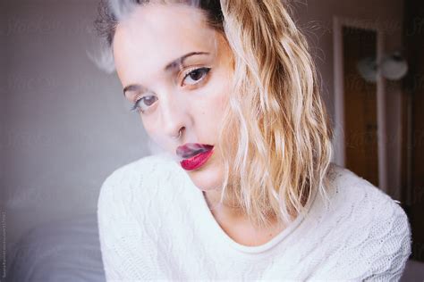 portrait of a woman blowing smoke by stocksy contributor susana ramírez stocksy