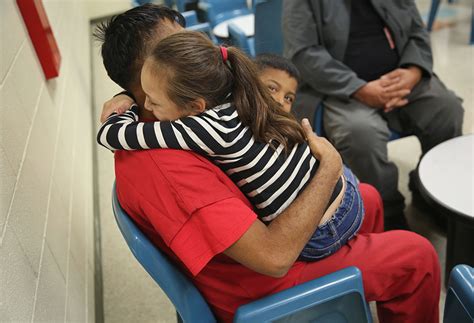 An Immigration Detainee Embraces His Children During An Ice Hearing At